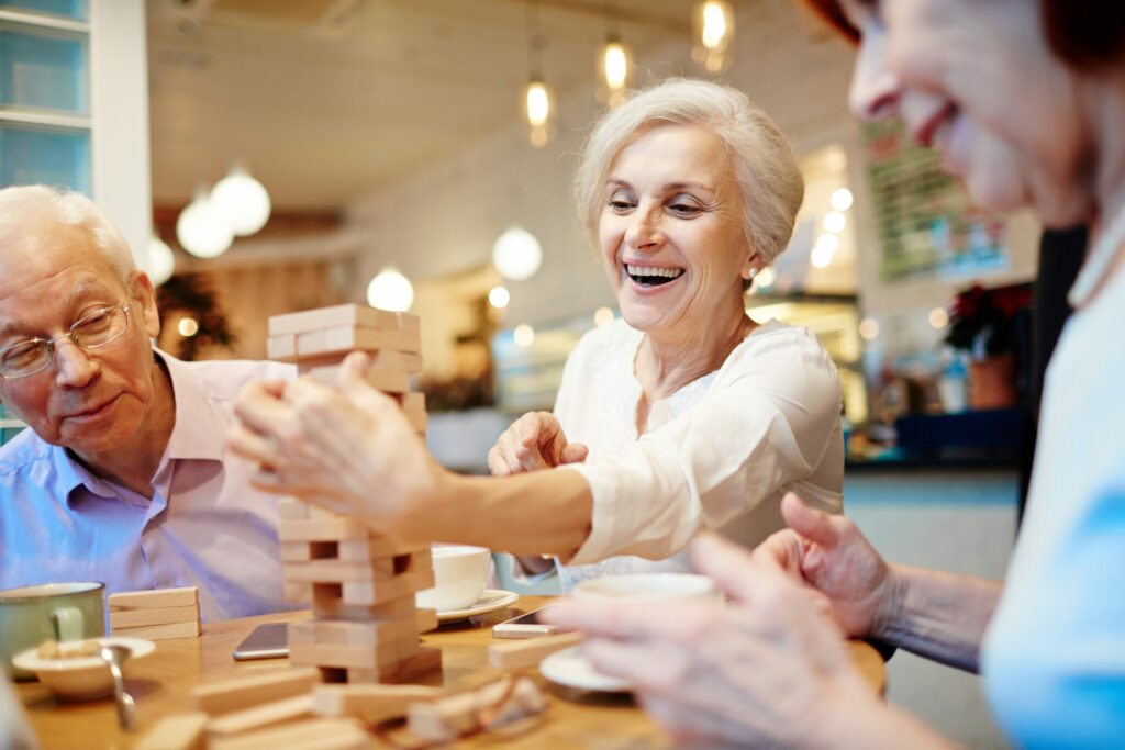 A group of old people happily playing Jenga.