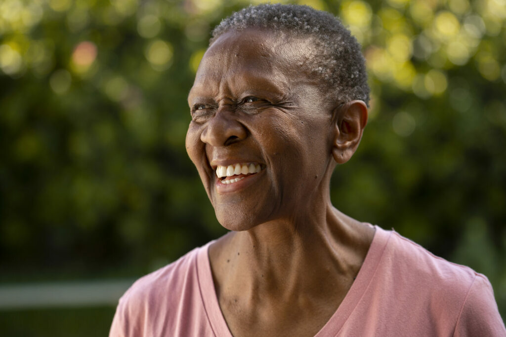 An elderly woman with a joyous smile on her face.