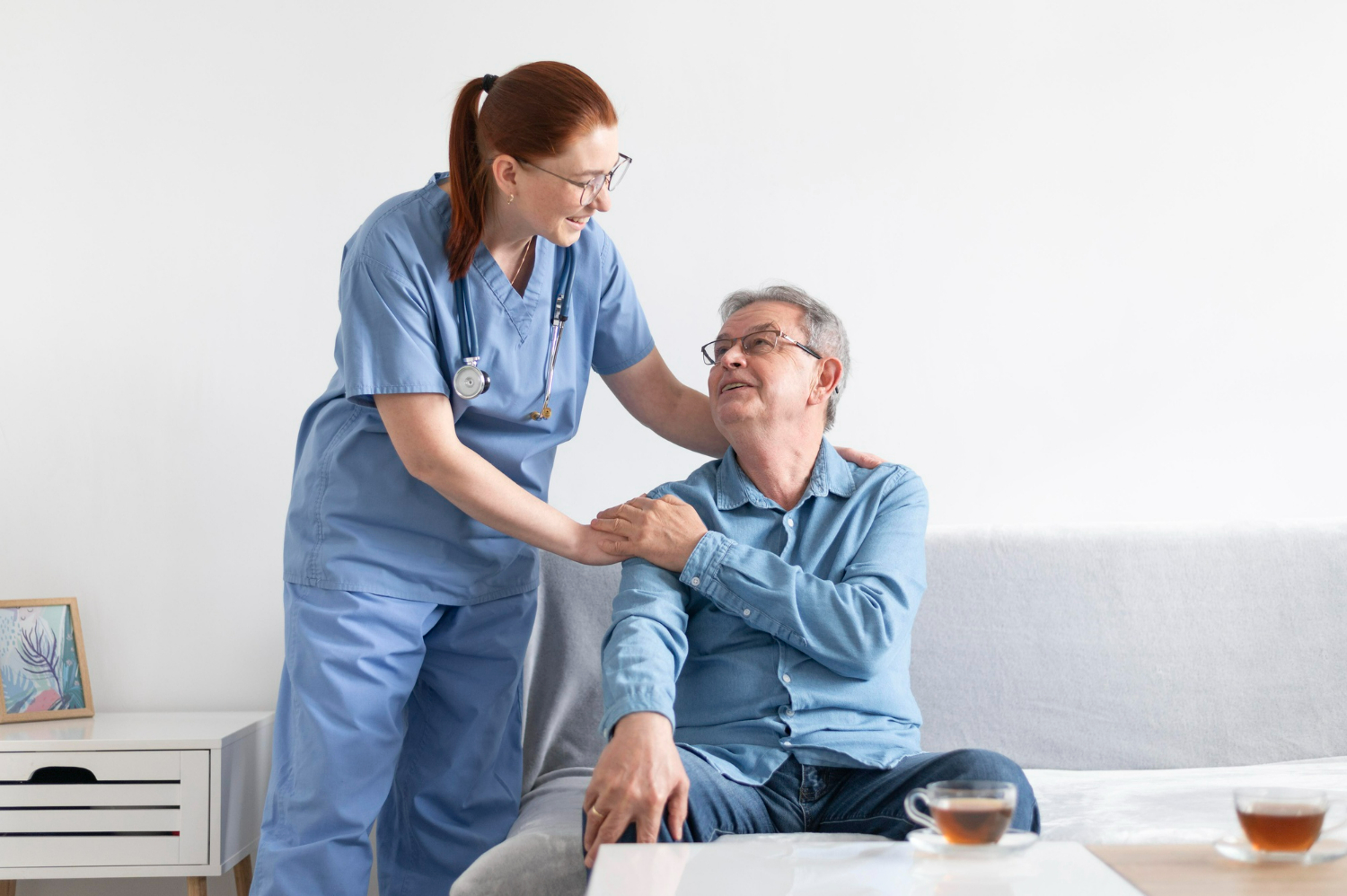 An elderly man being tended to by a nurse.